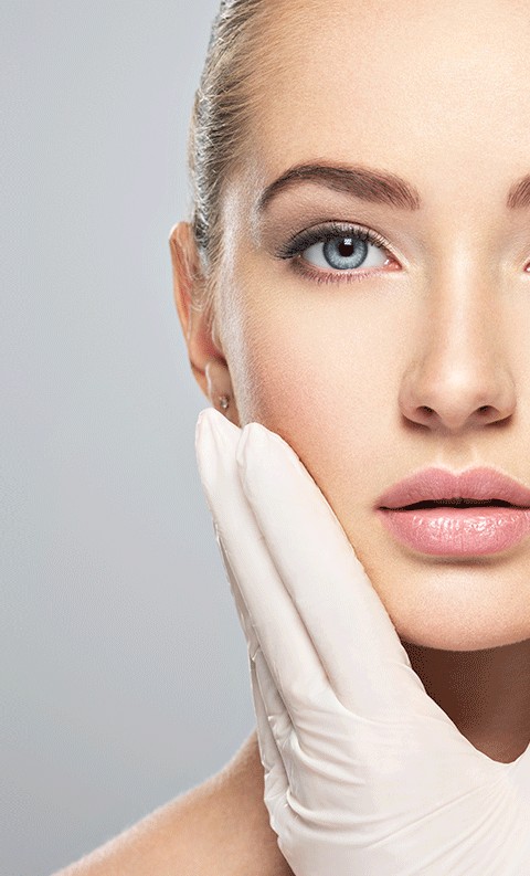 Woman holding face with surgical gloved hand