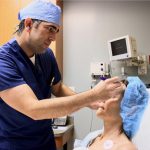 Dr. Joseph preparing to perform surgery on patient in chair