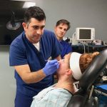 Dr. Joseph and fellow doctor preparing to perform surgery on patient in chair