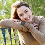 Woman leaning on fence outside