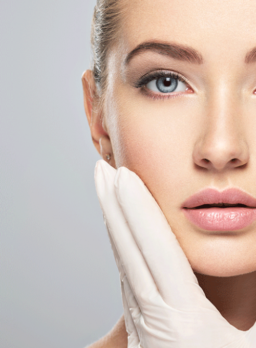 Woman holding face with surgical gloved hand