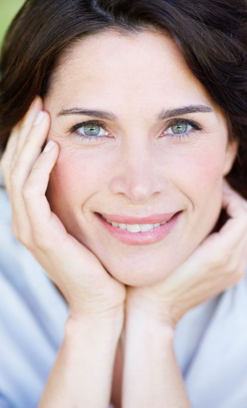 Front angle smiling woman framing face with hands