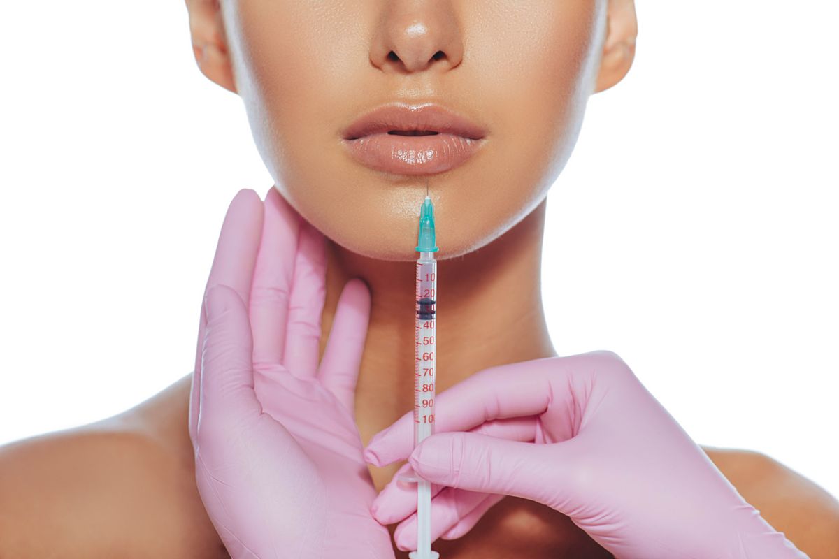 Women having syringe inject injectable fillers into lips