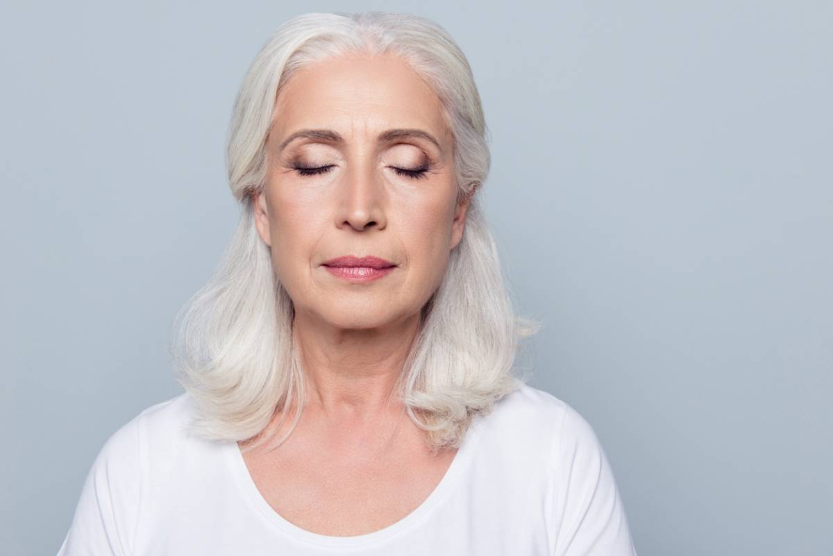 Older woman white hair peaceful look closed eyes front angle