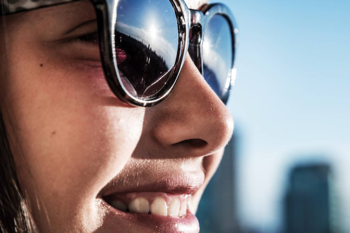 Closeup portrait of girl in sunglasses smiling.