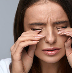 Woman placing hands under eyes